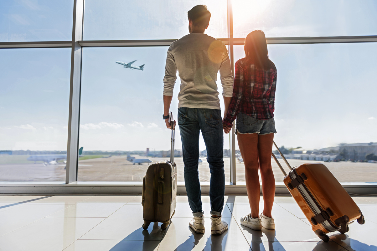 Dreamful loving couple looking at flying plane